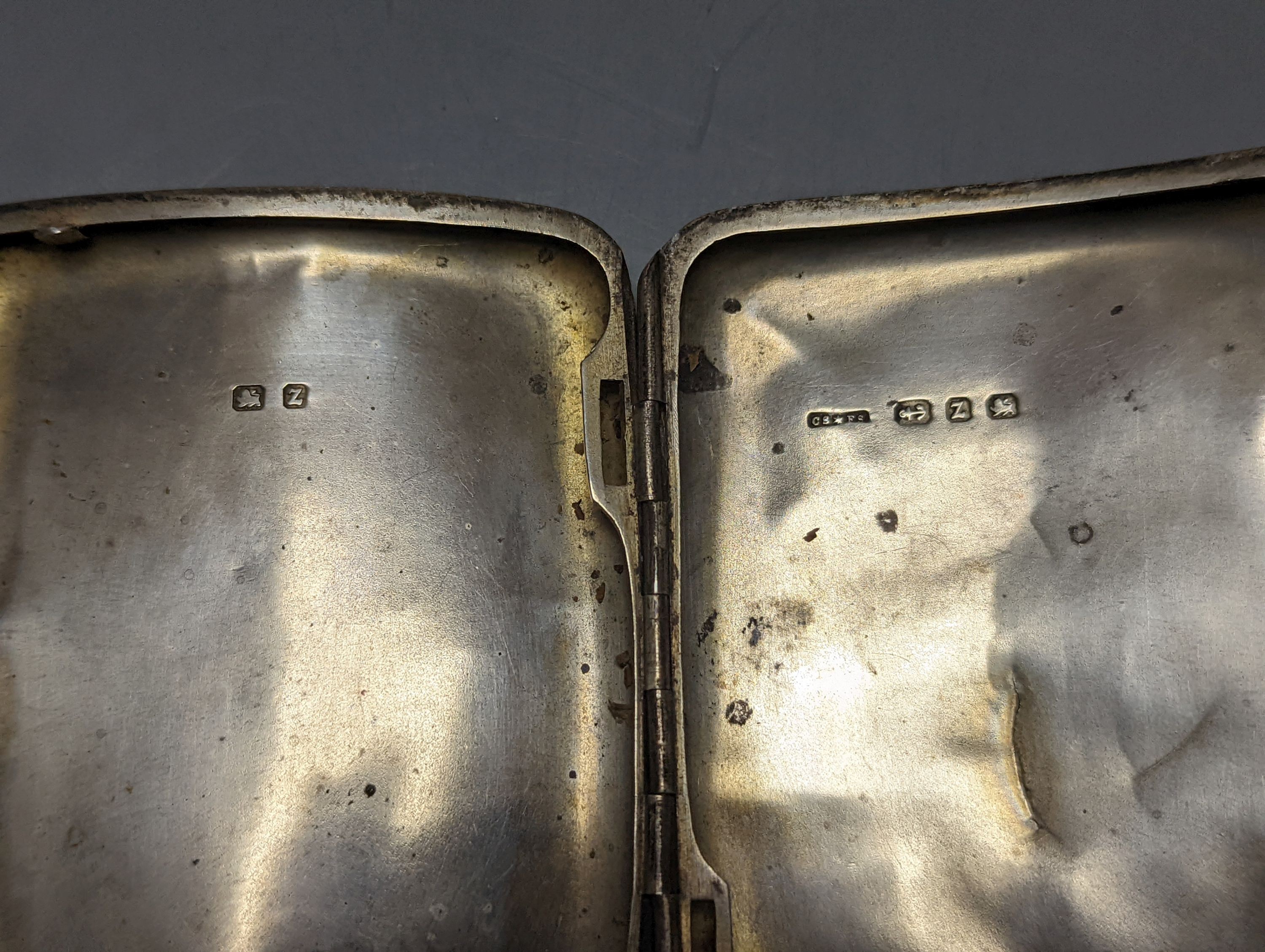 A George V silver cigarette case, an earlier silver vesta case and a cased set of button hooks, shoe horn and glove stretchers.